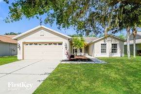 Parrish house for rent - a white house with a driveway and a garage door