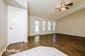 Parrish house for rent - an empty living room with a white door and a ceiling fan