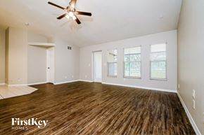 Parrish house for rent - the living room of an empty house with a ceiling fan
