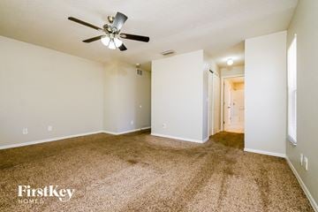 Parrish house for rent - a spacious living room with carpet and a ceiling fan