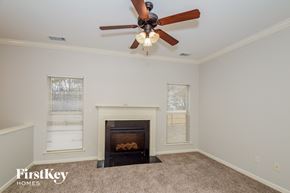 Chelsea house for rent - a living room with a ceiling fan and a fireplace