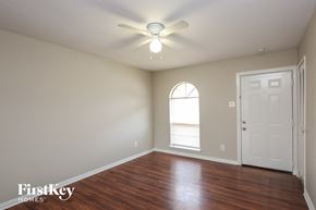 Garland house for rent - A room with a wooden floor and a ceiling fan.
