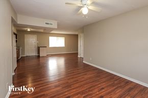 Garland house for rent - A spacious room with wooden floors and a ceiling fan.