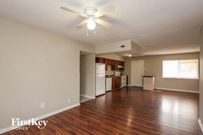 Garland house for rent - A room with a ceiling fan and wooden floors.