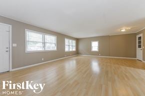 Independence house for rent - A spacious room with wooden flooring and white walls.