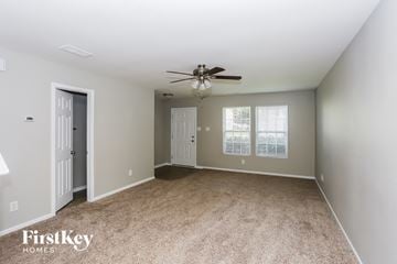 Charlotte house for rent - a spacious living room with carpet and a ceiling fan