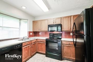 Kingwood house for rent - A kitchen with wooden cabinets and black appliances.