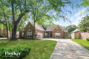 Kingwood house for rent - a large brick house with a driveway and a tree