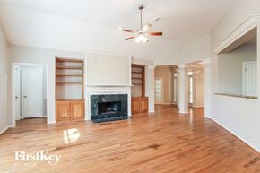 Kingwood house for rent - a living room with a fireplace and wooden floors and a ceiling fan