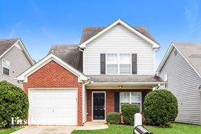 Mcdonough house for rent - A house with a red brick facade and a white garage door.