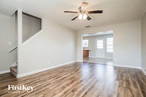 Mcdonough house for rent - A spacious room with wooden floors and a ceiling fan.