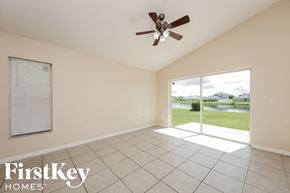 Kissimmee house for rent - a living room with a large window and a ceiling fan