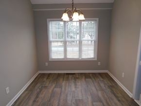 Powder Springs house for rent - an empty living room with a window and wood floors