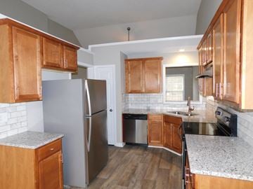 Powder Springs house for rent - a kitchen with wooden cabinets and a stainless steel refrigerator