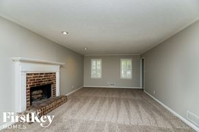 Marietta house for rent - A spacious room with a fireplace and carpeted floor.