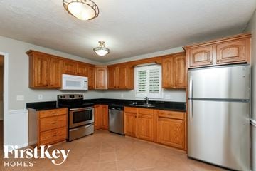 Marietta house for rent - A kitchen with wooden cabinets and a stainless steel refrigerator.