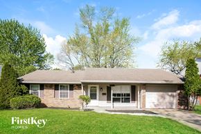 Indianapolis house for rent - a white brick house with a lawn and trees