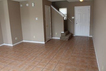 Indianapolis house for rent - an empty living room with a tiled floor and a staircase