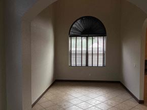 Homestead house for rent - an empty room with a large window and a tiled floor