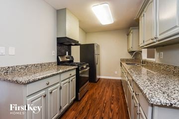Marietta house for rent - a kitchen with granite counter tops and a black refrigerator