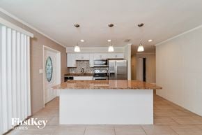 Bradenton house for rent - A kitchen with a white island and a fridge.