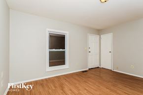Indianapolis house for rent - a bedroom with white walls and a window and wooden floors