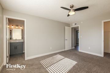 Phoenix house for rent - a spacious living room with carpet and a ceiling fan