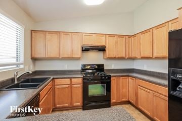 Glendale house for rent - A kitchen with wooden cabinets and black appliances.