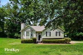 Powder Springs house for rent - A house with a green lawn and trees in the background.