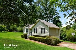 Powder Springs house for rent - A house with a green lawn and trees in the background.