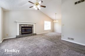 Powder Springs house for rent - A spacious room with a fireplace and a ceiling fan.