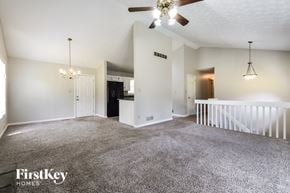 Powder Springs house for rent - A spacious living room with a ceiling fan and a chandelier.