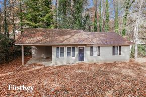 Gainesville house for rent - a small white house with a rusty roof in the woods