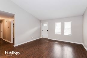 Gainesville house for rent - a living room with wood floors and white walls and a door