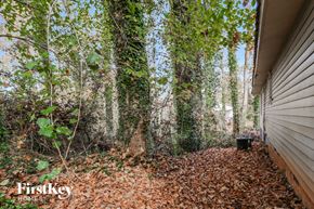 Gainesville house for rent - the side of a house in the woods with leaves and trees