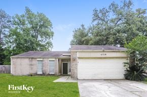 Spring house for rent - a small brick house with a white garage door and a lawn