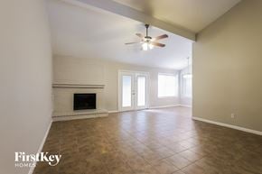 Spring house for rent - an empty living room with a fireplace and a ceiling fan