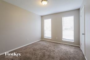 Spring house for rent - a bedroom with carpet and two windows and a door