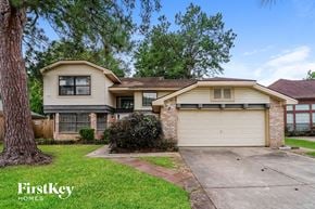 Houston house for rent - a home with a white garage door and a brick house