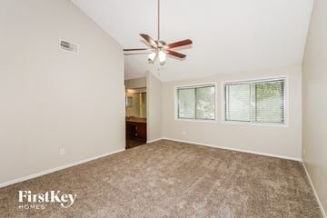 Houston house for rent - a spacious living room with carpet and a ceiling fan