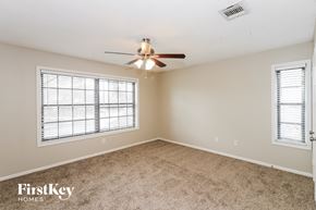 Houston house for rent - a bedroom with a ceiling fan and a window