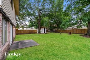 Houston house for rent - a backyard with a fence and a yard with grass and trees