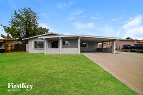 Phoenix house for rent - a white brick house with a lawn and a driveway