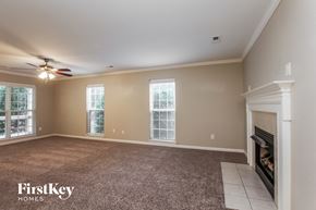 Indian Trail house for rent - an empty living room with a fireplace and a ceiling fan