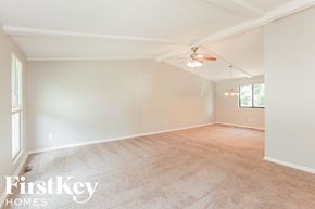 Indianapolis house for rent - A spacious room with a ceiling fan and light fixture.