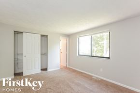 Indianapolis house for rent - A room with a carpeted floor and a window showing trees outside.