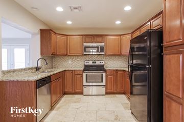 Phoenix house for rent - A kitchen with wooden cabinets and a black refrigerator.