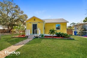 St. Petersburg house for rent - a small yellow house with a lawn and a porch