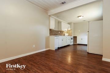 St. Petersburg house for rent - a kitchen with white cabinets and a wood floor