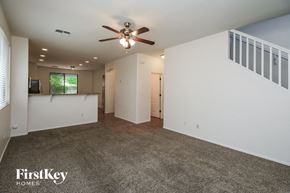 Gilbert house for rent - A spacious room with a ceiling fan and a carpeted floor.